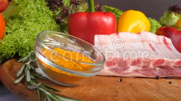 在生菜叶香料咖喱辣椒等蔬菜的背景下不同种类的肉放在木板上视频的预览图