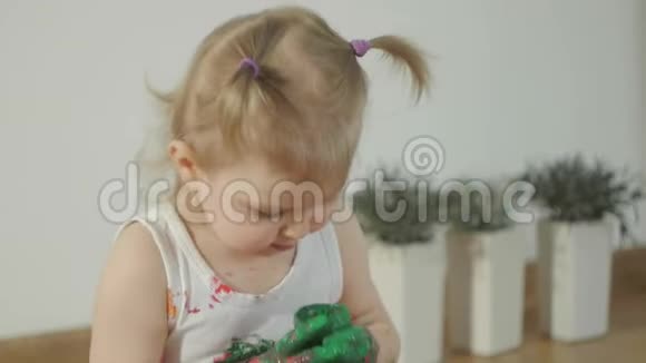 特写一个小女孩脏兮兮的五彩颜料孩子学会用手指画视频的预览图