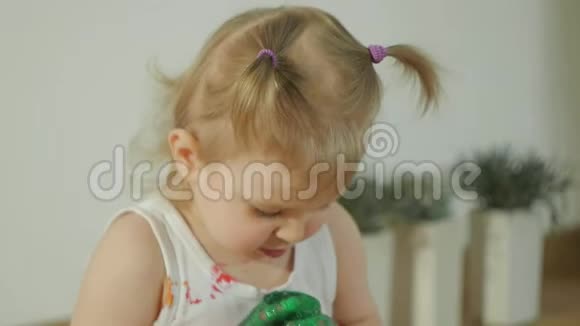 特写一个小女孩脏兮兮的五彩颜料孩子学会用手指画视频的预览图