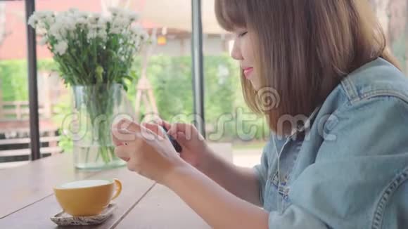 女博主用手机在咖啡馆里拍摄绿茶一位年轻女子在智能手机上拍咖啡茶视频的预览图