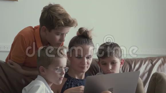 有小儿子的女人在家里用笔记本电脑看电影视频的预览图