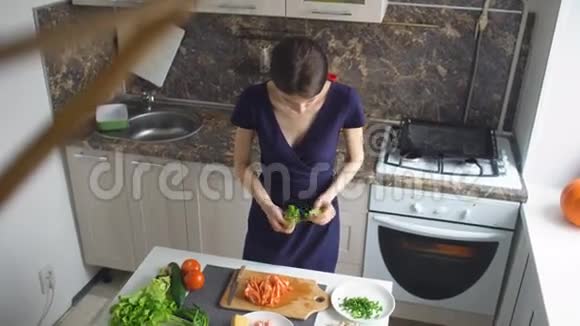 美丽的女人在家厨房做饭切蔬菜的俯视图视频的预览图
