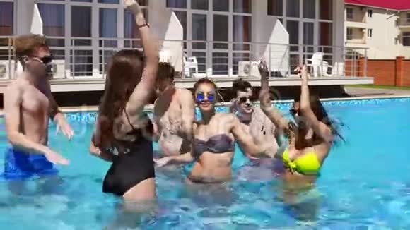 快乐的年轻快乐的朋友跳舞在游泳池里玩在炎热的夏天在水中冷却夏季视频的预览图