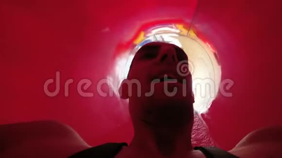 一个人从极端水中滑下的红色管道的脸波夫慢动作视频的预览图