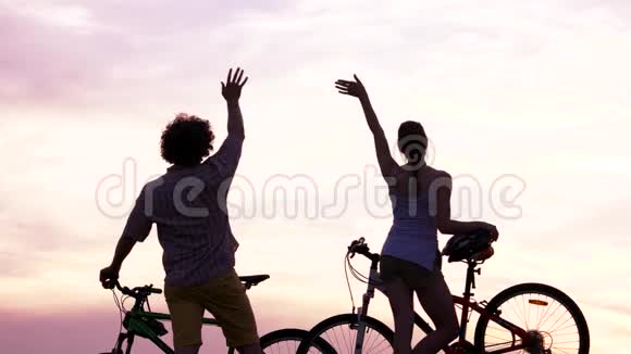 日落时骑自行车的年轻夫妇视频的预览图