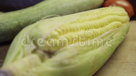新鲜的玉米在绿色的叶子上蔬菜在背景上视频的预览图