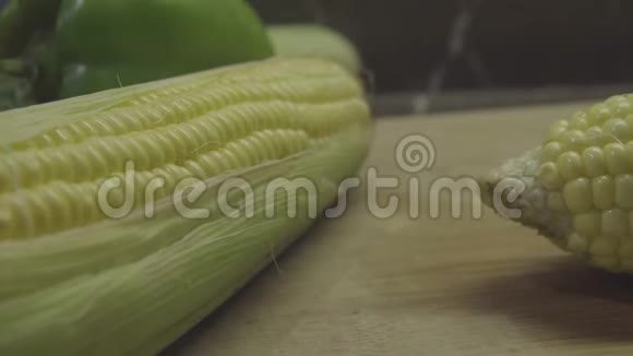 新鲜的玉米在绿色的叶子上蔬菜在背景上视频的预览图