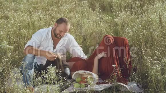 恋爱中的情侣在草地上的格子布下放松视频的预览图