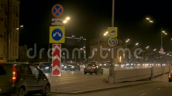 汽车密集的交通沿着城市街道在桥上晚上视频的预览图
