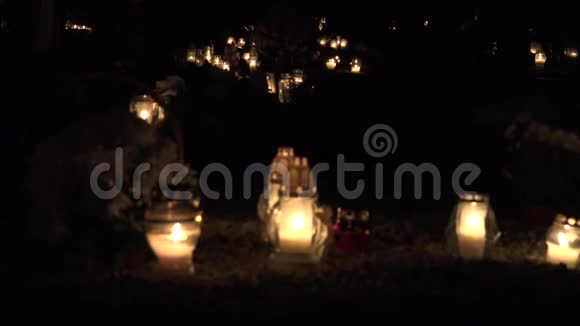 墓地上的五颜六色的蜡烛在夜间圣徒日4K视频的预览图