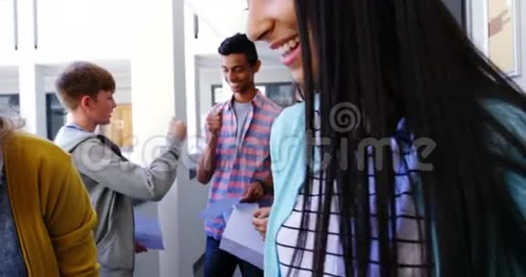 微笑的学生在走廊里互相挥拳视频的预览图