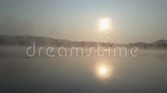 空中飞行穿过晨雾飞越一个山湖山脉中雾状的日出视频的预览图