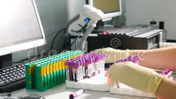 实验室分析诊断机装有带血的容器或试管的机器人机械臂视频的预览图