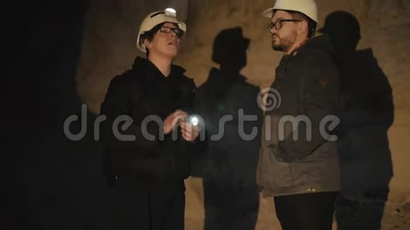 两个拿着手电筒的专家在黑暗中恐惧地探索洞穴视频的预览图