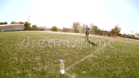 小男孩足球运动员在训练期间从塑料瓶里喝水青少年踢足球视频的预览图