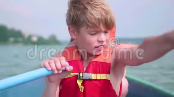 那家伙漂浮在船上青少年在桨的帮助下独立操作一艘船极限运动视频的预览图