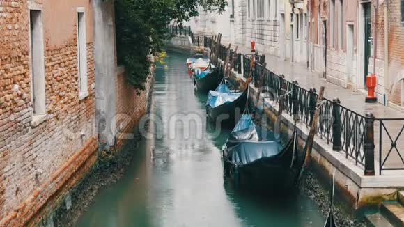 威尼斯意大利2017年9月7日威尼斯贡多拉斯站在雨中的运河上美丽的黑色贡多拉斯站和岩石视频的预览图