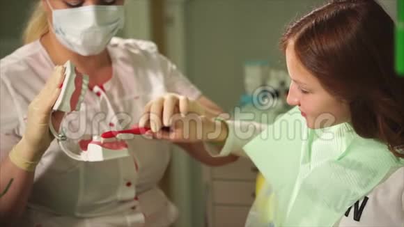 年轻的女牙医教她十几岁的病人如何清洁牙齿视频的预览图