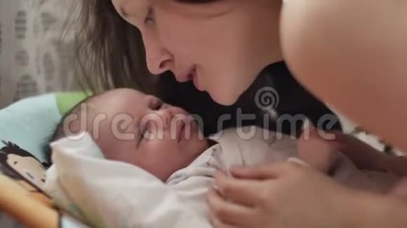 美丽的年轻母亲微笑着亲吻她的孩子视频的预览图