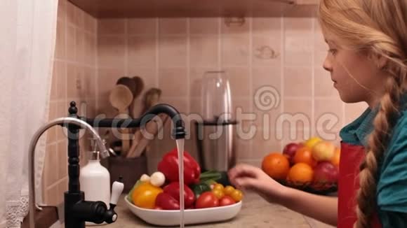 小女孩在厨房的水槽里洗一个红色的喇叭视频的预览图
