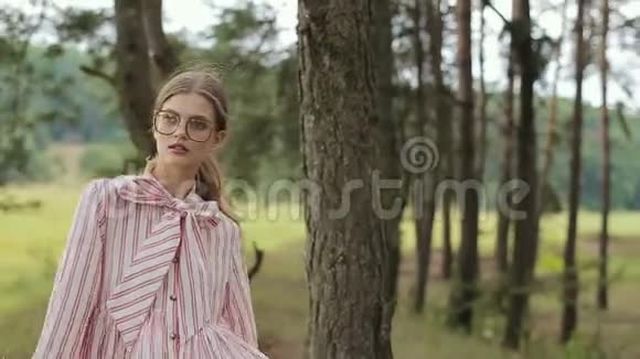 一个漂亮的女孩穿着有趣的衣服和戴着眼镜的镜头的肖像视频的预览图