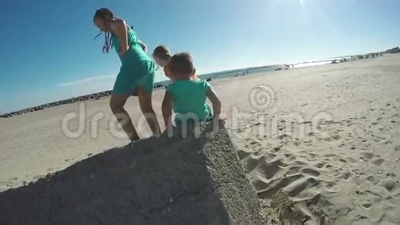 孩子们在一块大石头附近的海滩上玩耍视频的预览图
