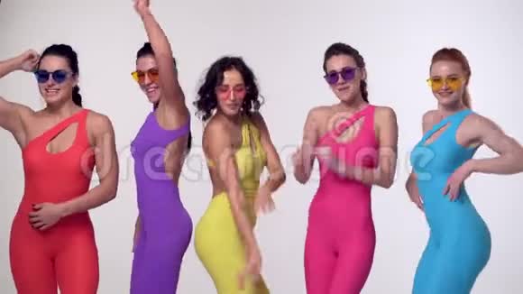 在工作室里穿着五颜六色的紧身衣跳舞的无忧无虑的女孩视频的预览图