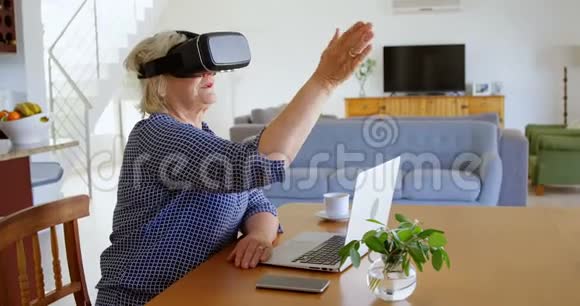 家中使用虚拟现实耳机的高级妇女视频的预览图
