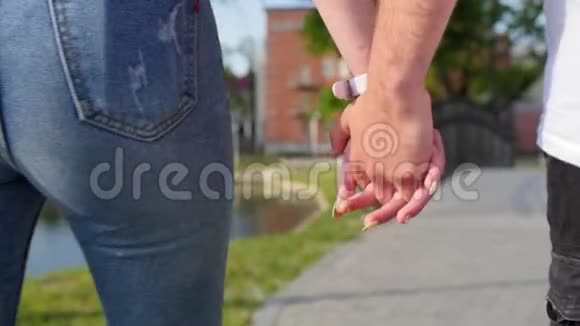 亲密的两个情人携手男女牵手在公园散步的细节剪影夫妇视频的预览图