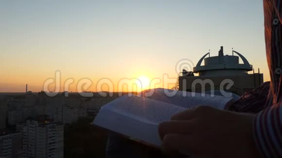 令人惊叹的日落坐在建筑和阅读的屋顶上的人视频的预览图