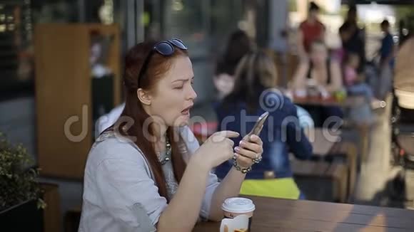 白种人中年妇女下班后坐在夏天的咖啡馆里吃薯条视频的预览图