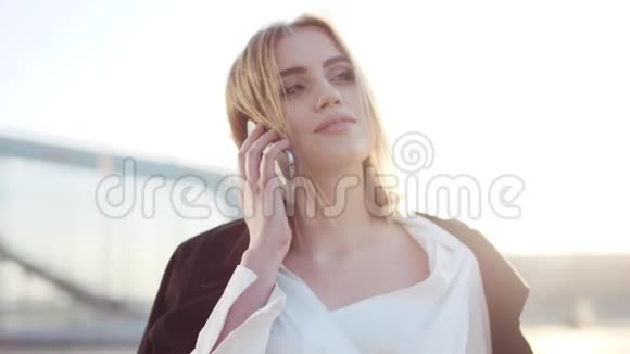 一个有魅力的年轻女商人在她的电话上交谈的旋转视图检查时间商业中心视频的预览图
