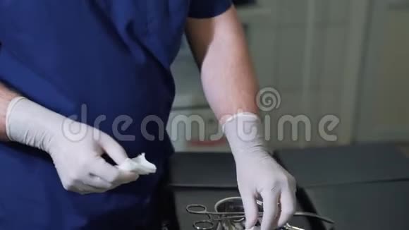 戴无菌手套的男医生从包裹中取出医疗餐巾纸并将其插入夹子前视频的预览图
