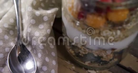 4k玻璃罐内有石榴和金浆果的酸奶视频的预览图