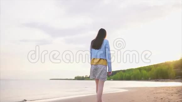 一个穿着现代服装的瘦小少年在一片荒芜的沙滩上漫步视频的预览图