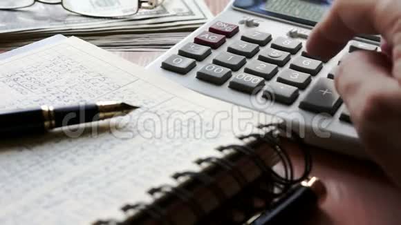 会计使用计算器检查财务报告有文件的桌子视频的预览图