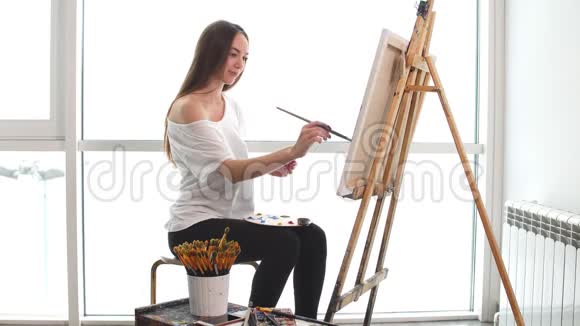 女画家在画架上画一幅画画中画的是油画视频的预览图