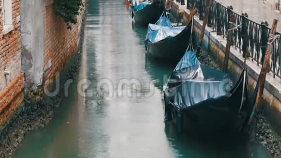 威尼斯意大利2017年9月7日威尼斯贡多拉斯站在雨中的运河上美丽的黑色贡多拉斯站和岩石视频的预览图