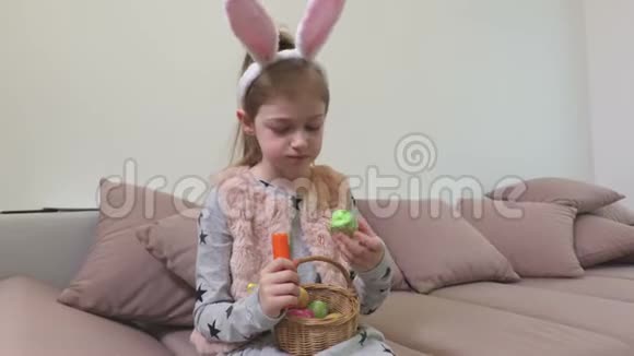 有兔子耳朵的女孩吃胡萝卜的复活节彩蛋视频的预览图