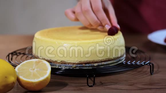 厨房里的一个女人装饰着纽约的覆盆子芝士蛋糕纽约香草芝士蛋糕和覆盆子视频的预览图