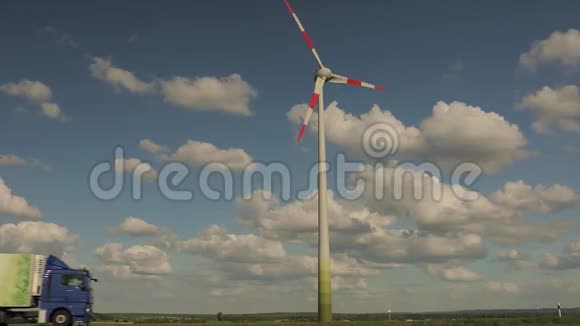 在阳光明媚的天气里一台在野外的发电机一台在百叶窗云层和一台有红色条纹的白色风力发电机视频的预览图