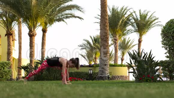 时间推移是一个运动女孩谁做了一套基本的练习与瑜伽清晨在度假村视频的预览图