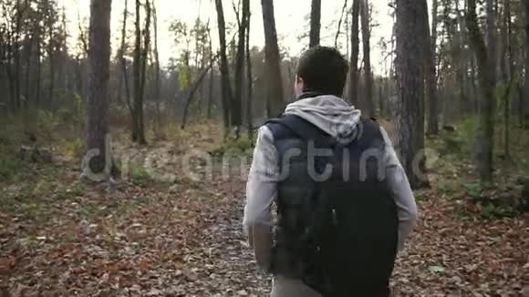 年轻人在秋天的树林里散步享受好天气视频的预览图