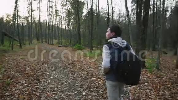 成年男性穿着热情的衣服在树林里散步享受森林视频的预览图