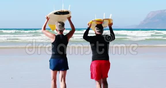 一对年长夫妇带着冲浪板朝大海跑去视频的预览图