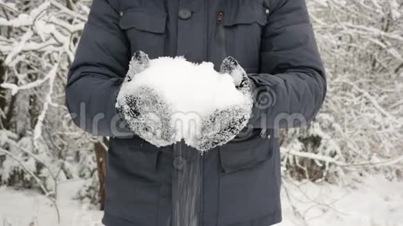 一个穿着黑色手套的人手里拿着雪雪花飘落飘落视频的预览图
