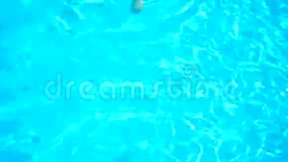 穿着泳衣和帽子的年轻女孩去纯蓝色游泳池视频的预览图