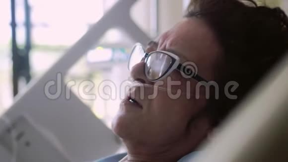 一位戴眼镜的老年妇女被关在一张病床上上面滴着氧气罩4k3840x2160视频的预览图