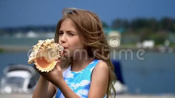 这个女孩在一个有船的码头手里拿着一只公鸡壳那个女孩玩一个大公鸡女孩吹了视频的预览图