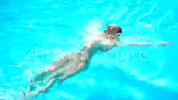 戴眼镜的年轻女孩在蓝色的游泳池里背上漂浮视频的预览图